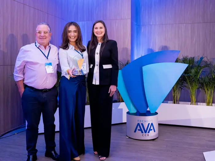 dos mujeres y un hombre, la mujer del centro sostiene un premio AVA junto a los otros. 